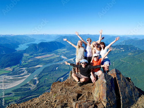Group of Happy Friends Cheering on Mountain Top. British Columbia, Canada. 