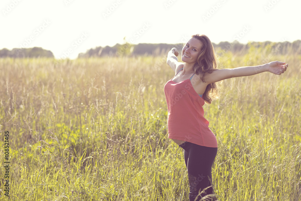 Young beautiful pregnant woman holding tummy smiling, in red a light summer dress, happy on meadow the grass Young beautiful pregnant woman holding tummy smiling, in red a light summer dress, happy on meadow the grass
