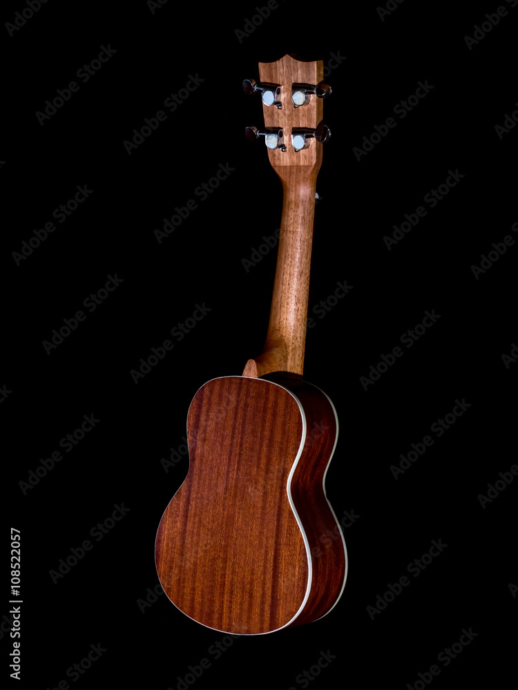 Naklejka premium back of hawaii ukulele guitar isolated against black background