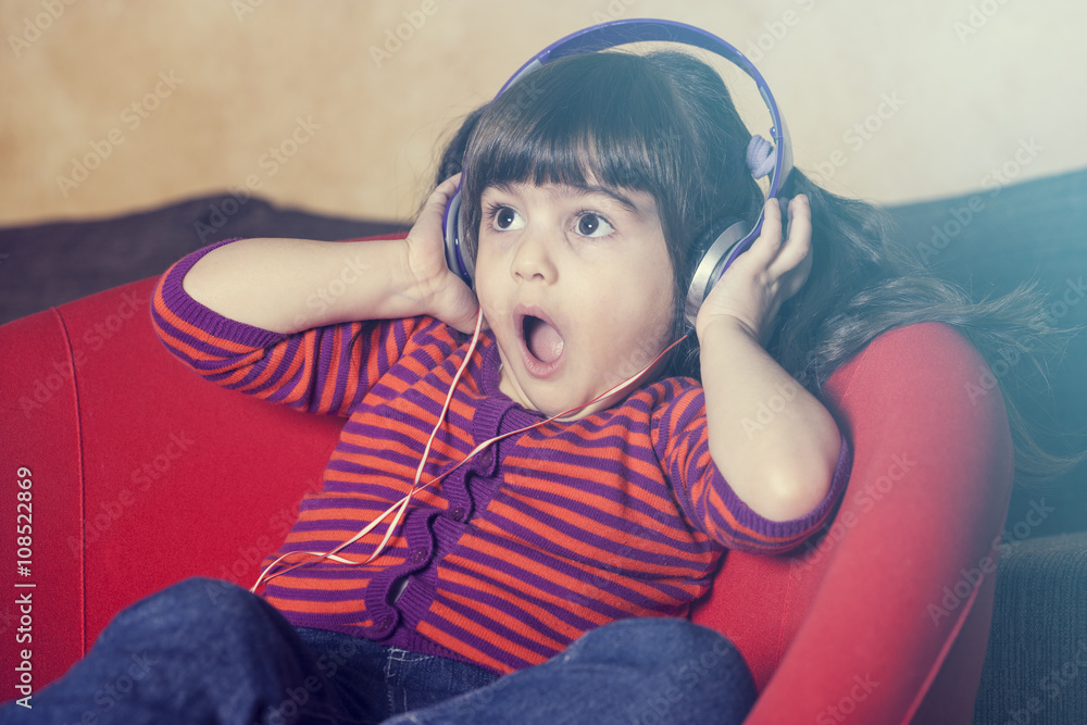 Cute little girl reacts while listening to music Stock Photo | Adobe Stock