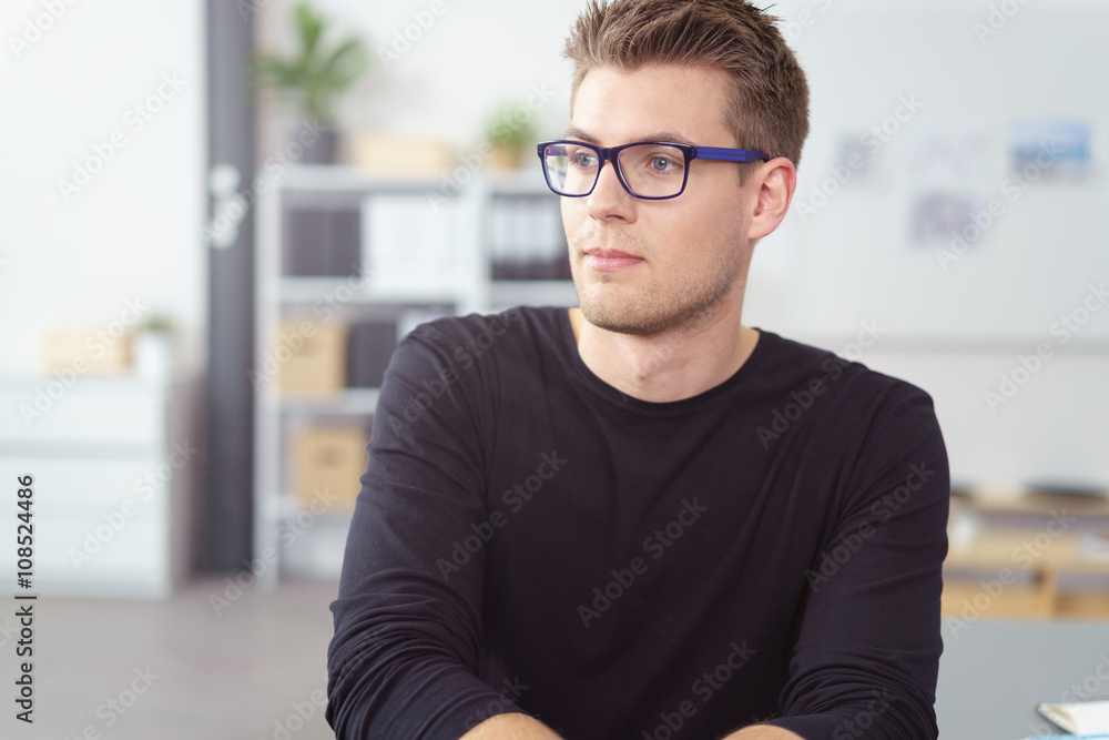 mann im büro schaut nachdenklich zur seite mann im büro schaut nachdenklich zur seite