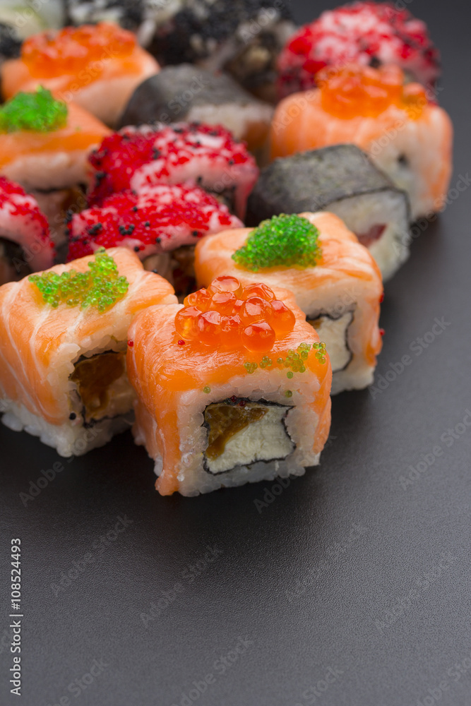 Japanese cuisine. Set of sushi mix roll with differen fresh ingredients over black background ( table ). Japanese cuisine. Set of sushi mix roll with differen fresh ingredients over black background ( table ).