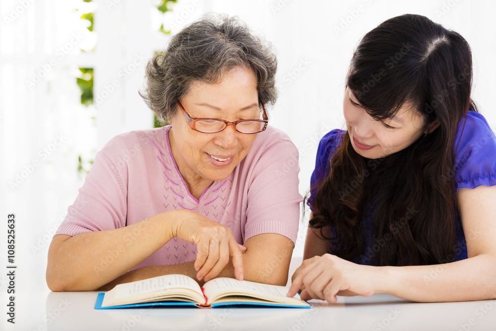 © Tom Wang - happy senior woman and  daughter  reading a book