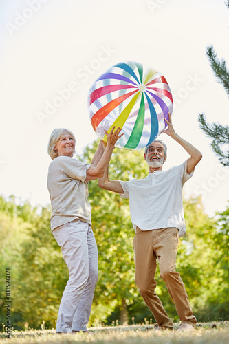 Glückliches Senioren Paar wirft einen Ball