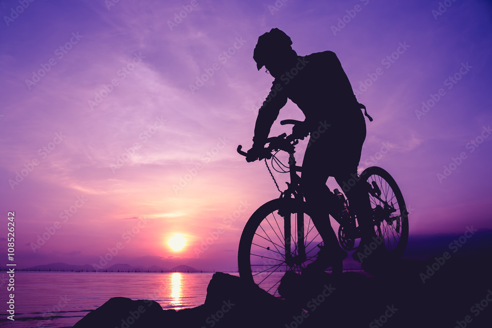 Obraz premium Healthy lifestyle. Silhouette of bicyclist riding the bike at seaside