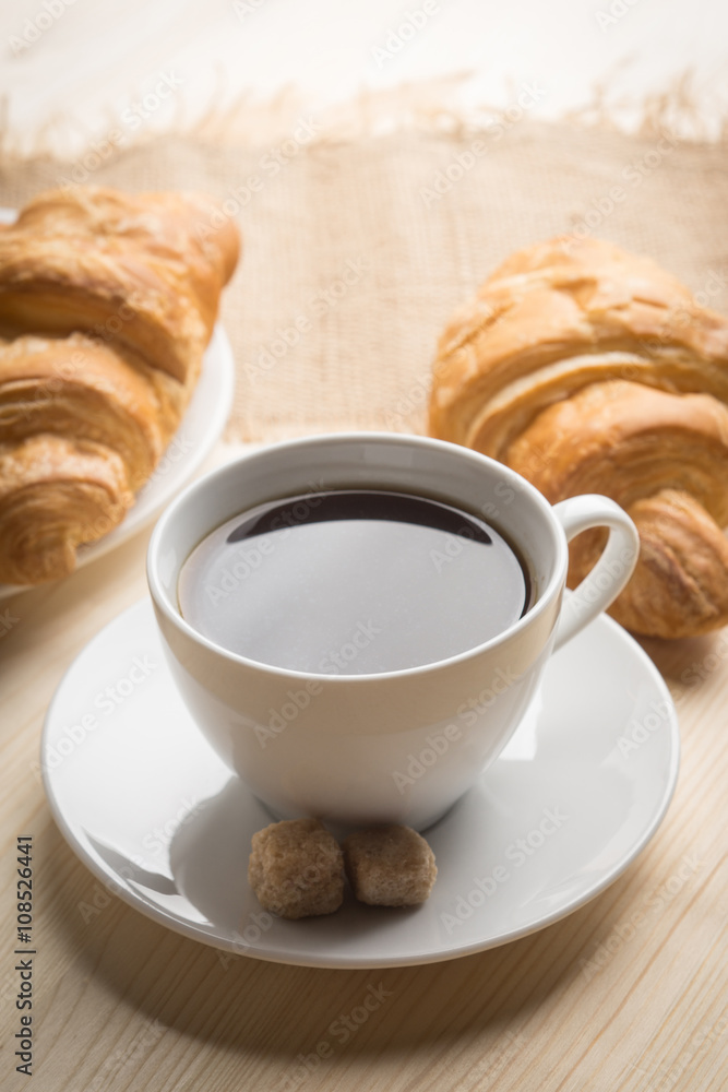 Croissants with cup of coffee on wooden background Croissants with cup of coffee on wooden background