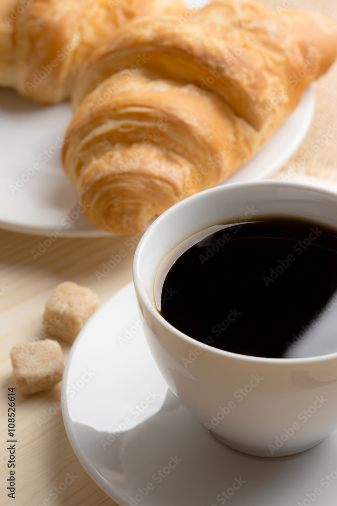 Croissants with cup of coffee on wooden background Croissants with cup of coffee on wooden background