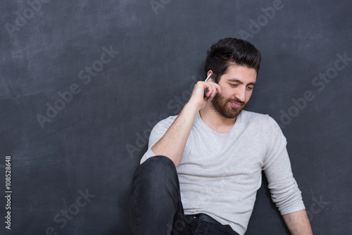 picture of young arab man on chalkboard using phone © Myvisuals