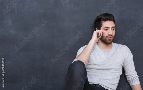 picture of young arab man on chalkboard using phone