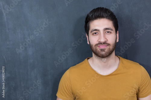 Attractive young man against blackboard. © Myvisuals