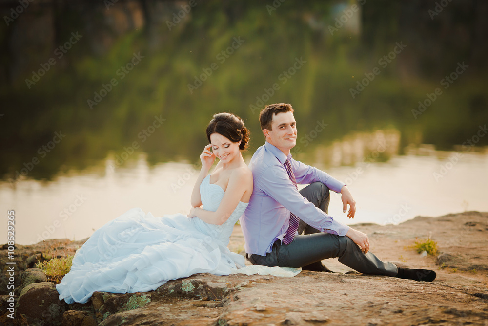 Happy bride and groom celebrating wedding day. Married couple sitting together