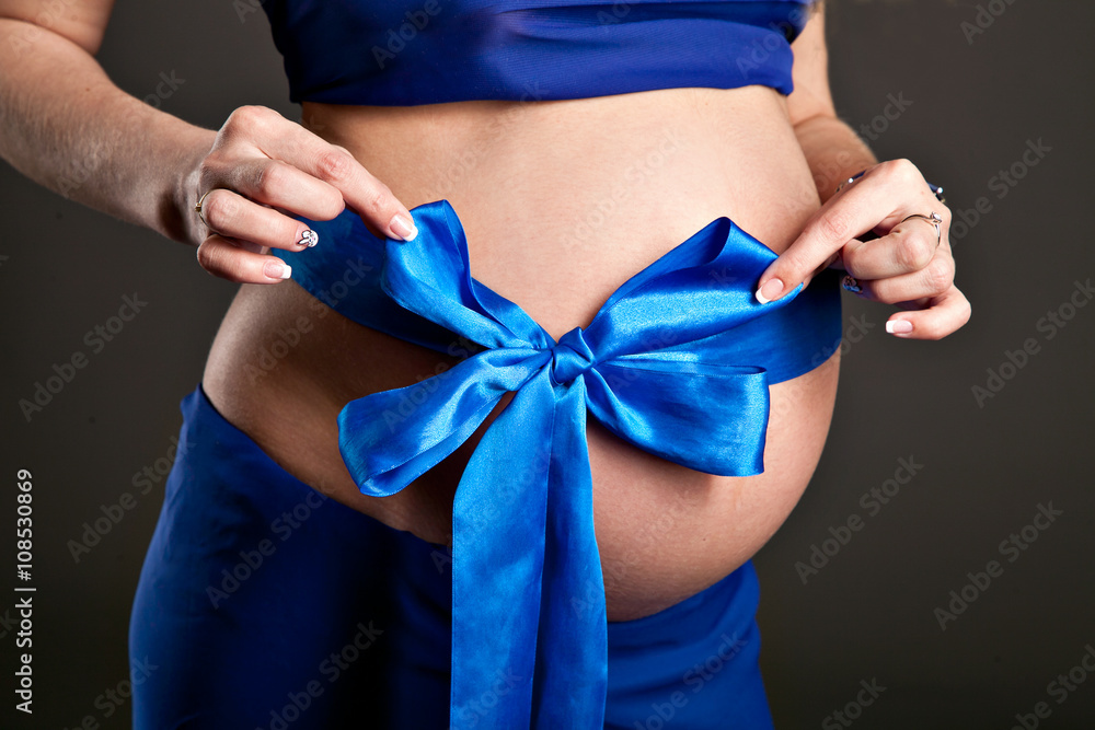pregnant woman's belly with blue bow pregnant woman's belly with blue bow