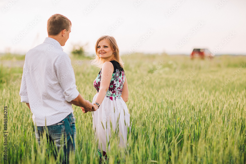 pretty pregnant with her husband in the field
