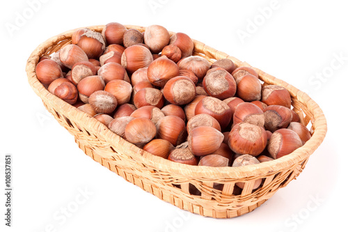 hazelnuts in a wicker basket isolated on white background