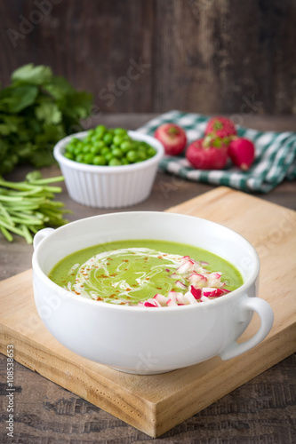 Peas cream with radishes on rustic wooden table 