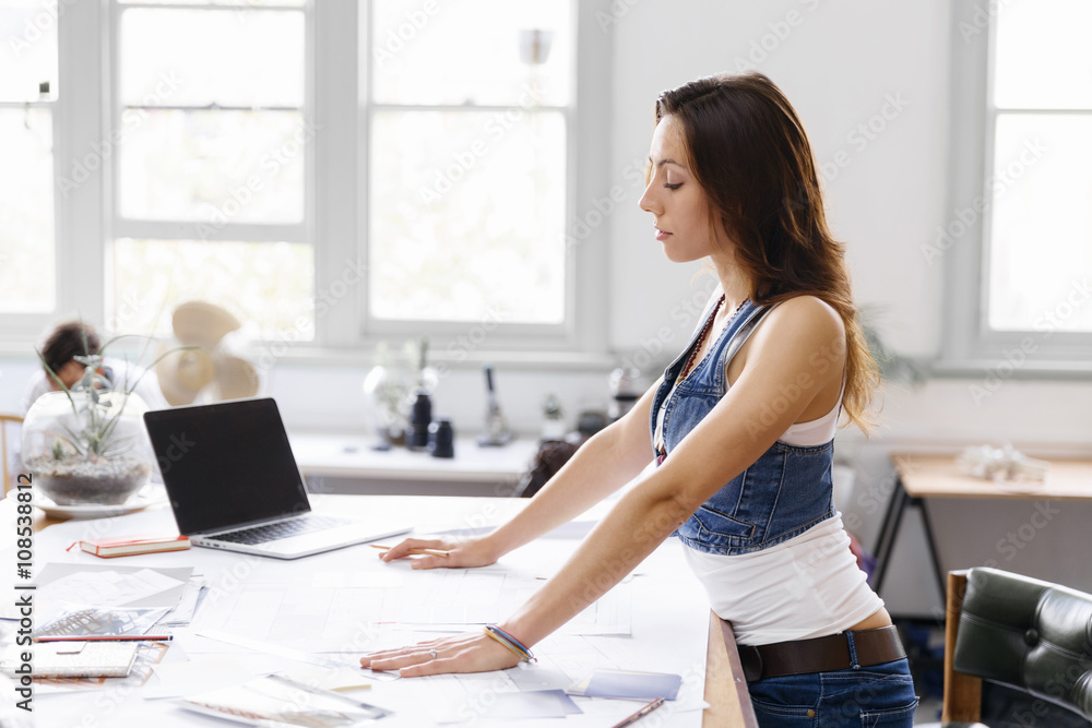 Naklejka premium Young woman standing in creative office