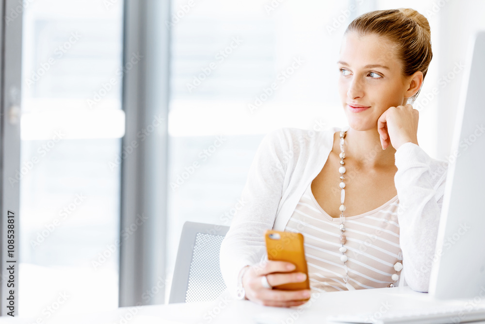 Attractive office worker sitting at desk Attractive office worker sitting at desk