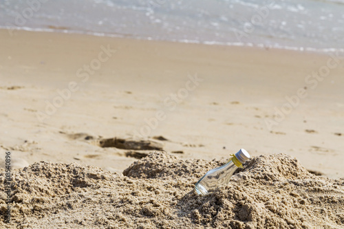 Empty glass bottle on the beach with copy space