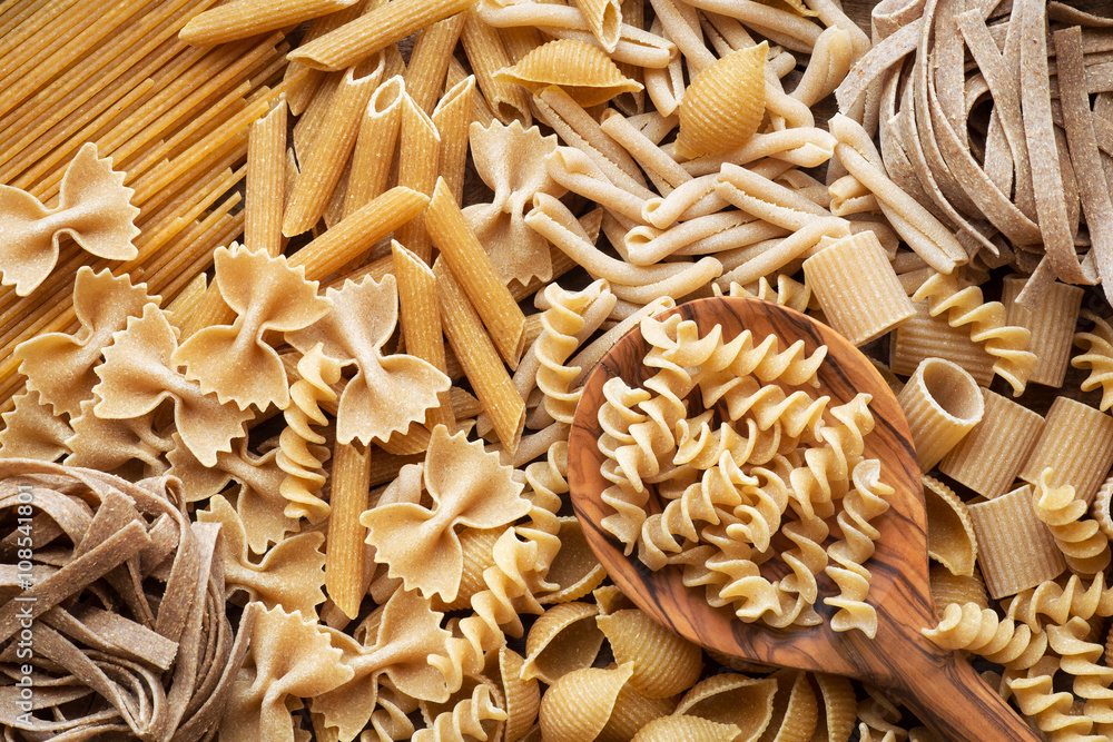 Variety of types and shapes of wholemeal pasta. Dry pasta background ...