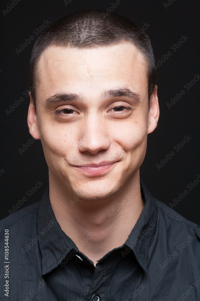 Fototapeta premium Smirking funny face portrait, young adult boy.