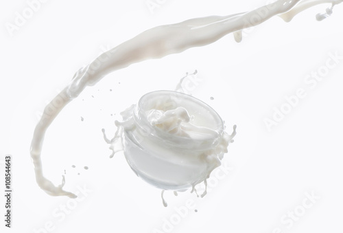 Moisturizing cream, moisturizing milk in the big milk splash isolated on the white background with milk drops