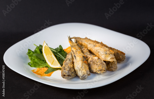 Fried fish gobies in batter with lemon and greens