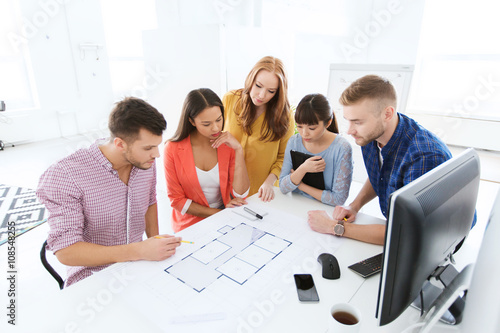 creative team with blueprint working at office