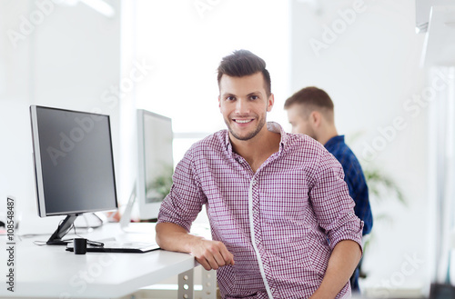 happy creative man with computer at office