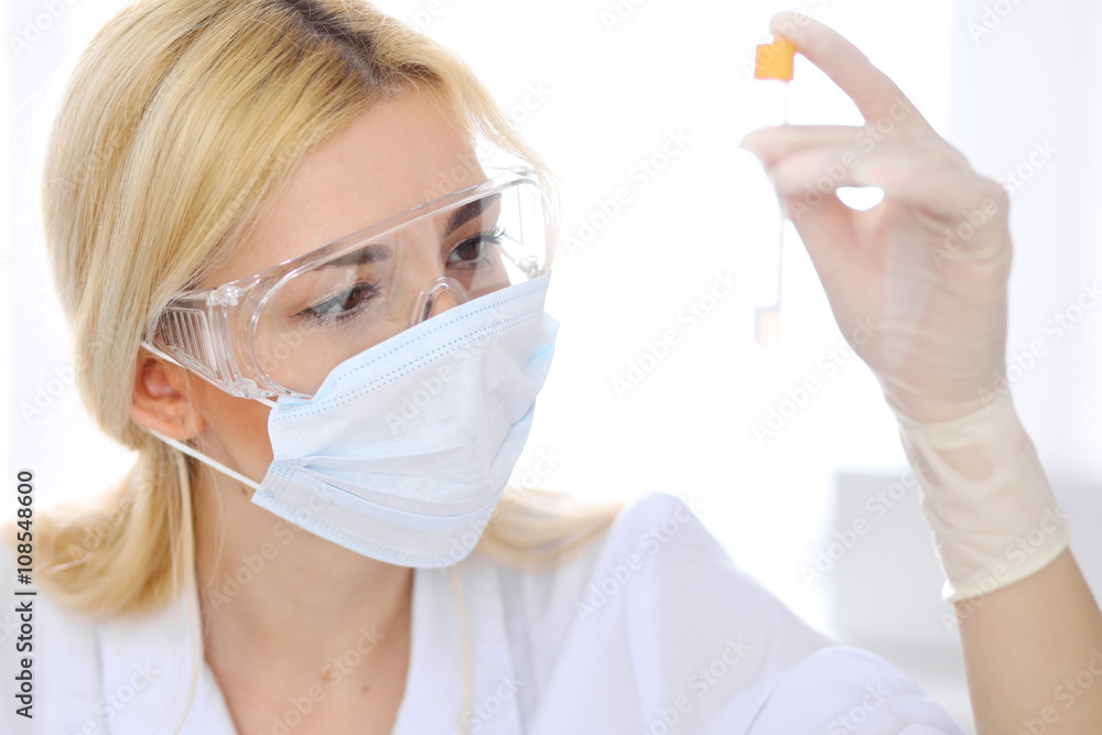 Female scientific research team with clear solution in laboratory Female scientific research team with clear solution in laboratory