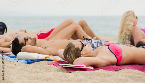 friends laying on sand at beach