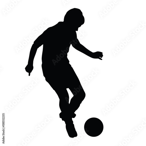 Young soccer player passes the ball silhouette, kid plays soccer