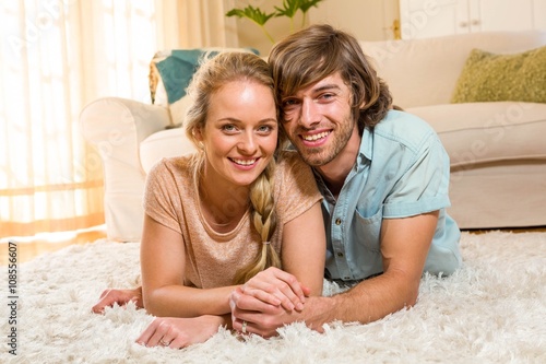 Schilderij op canvas Cute couple lying on the carpet