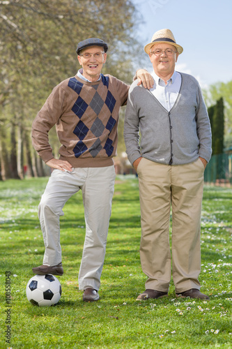 Two senior gentlemen posing with a football