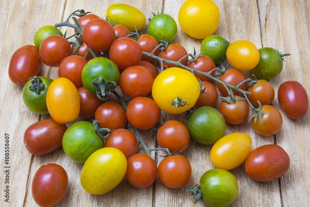 Fototapeta premium red, yellow and green tomatoes on a wooden table