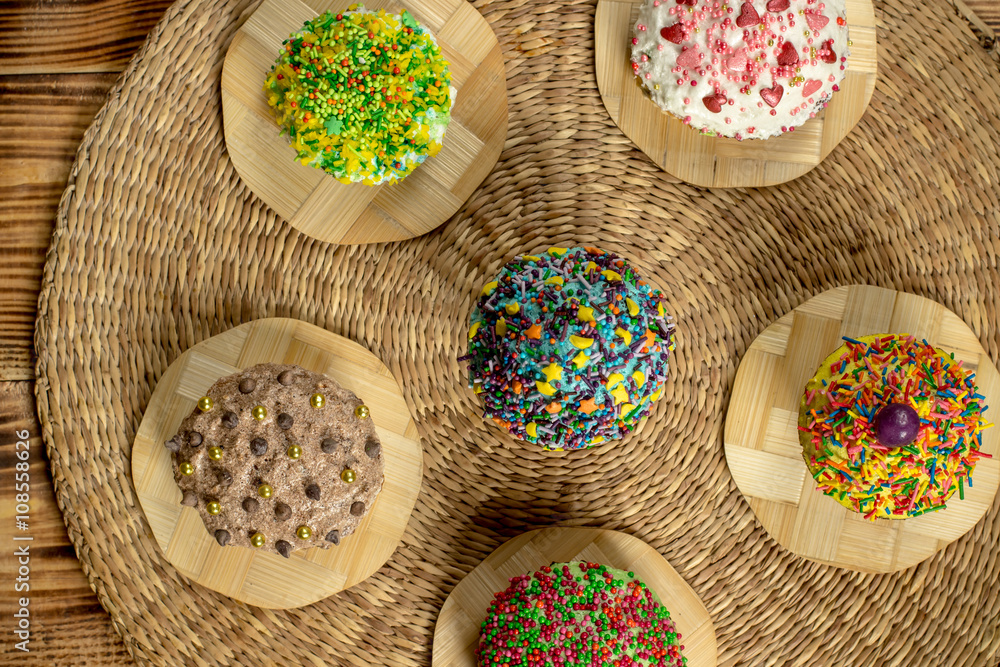 Multicolored cupcakes on wooden table