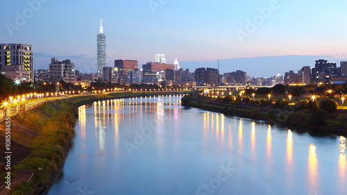 Beautiful riverside scenery of busy Taipei City with view Taipei 101 Tower, Keelung River and downtown area at dusk ~ A Blue and Gloomy evening in Taipei