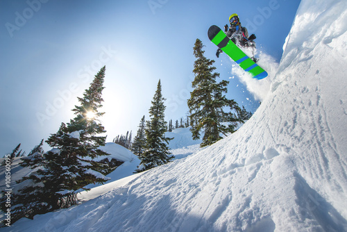 Flying snowboarder in the mountains