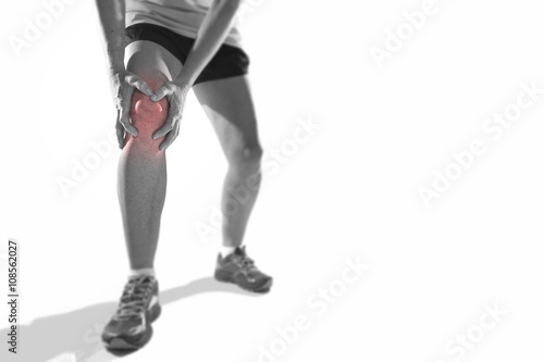  young sport woman with strong athletic legs holding knee with hands in pain suffering ligament injury