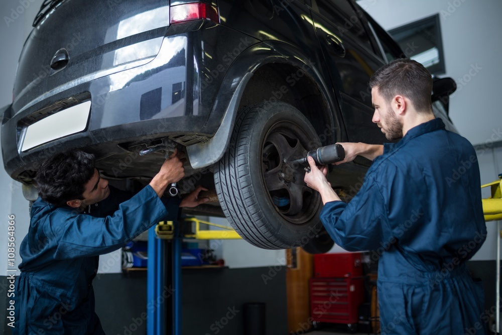 Mechanics fixing a car wheel Mechanics fixing a car wheel