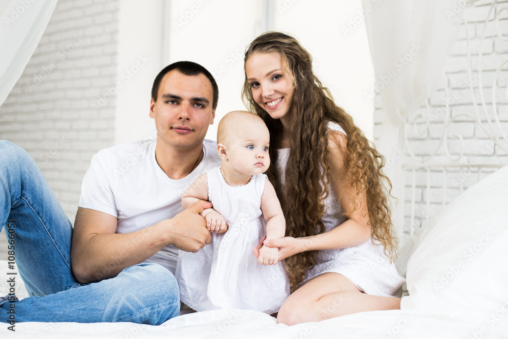 Mother and father with little baby in a bed Mother and father with little baby in a bed