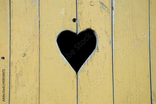 heart carved on an old yellow door