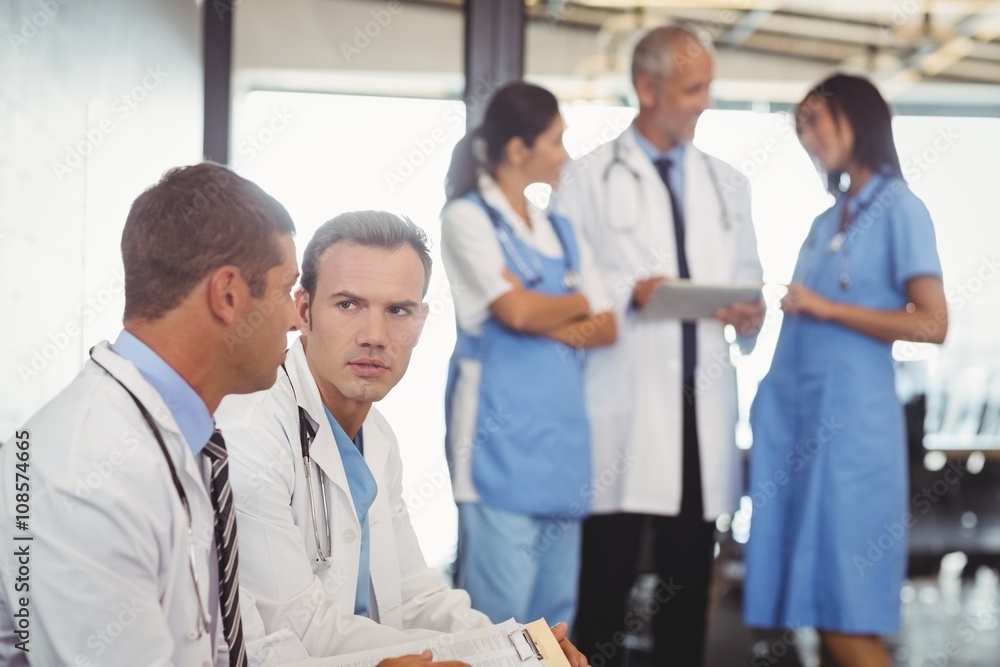 Two doctors with clipboard and discussing Two doctors with clipboard and discussing