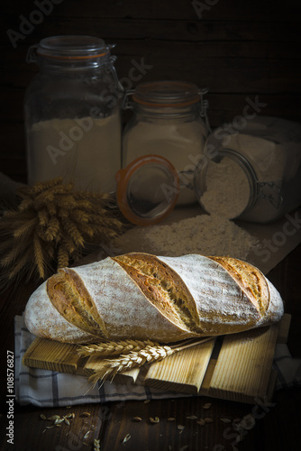 Pan de masa madre natural hecho a mano por un panadero tradicional decorado con espigas de trigo y centeno photo