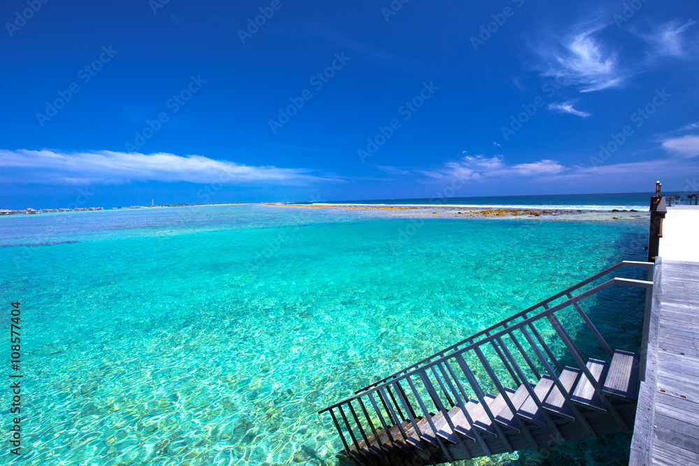 Tropical island with sandy beach with palm trees and tourquise clear water, Maldives