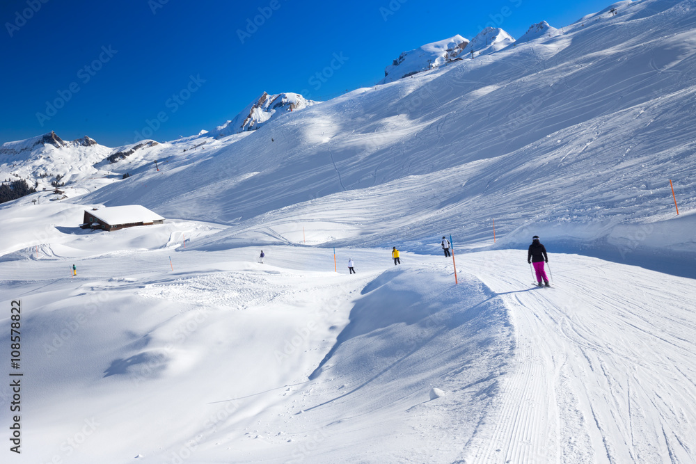 Skiers skiing on the top of the Hoch-Ybrig ski resort, Switzerland Skiers skiing on the top of the Hoch-Ybrig ski resort, Switzerland