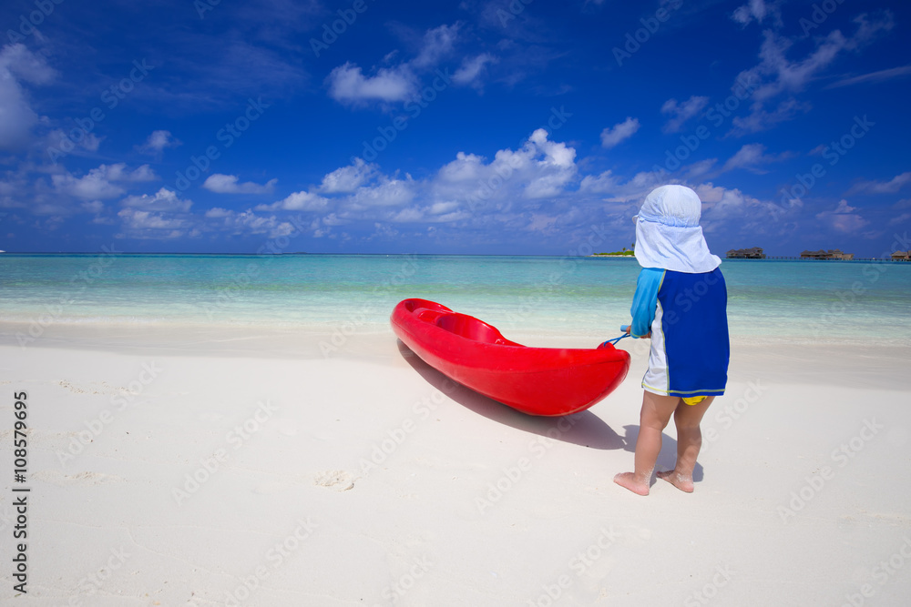 Little boy having fun with kayak in tropical lagoon Little boy having fun with kayak in tropical lagoon