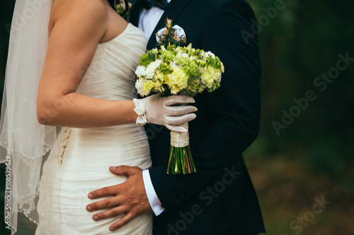 Elegant bride and groom posing together outdoors on a wedding day. Haging  kissing  embracing.