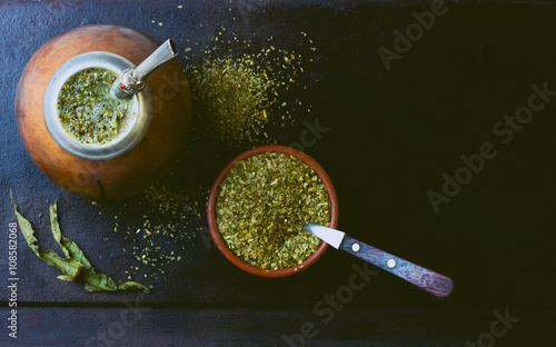 Foto Yerba mate in calabash and dry herb in clay bowl on black background