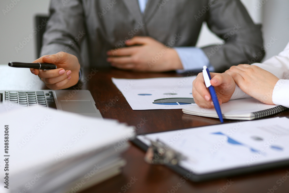 Close up of unknown business people at meeting discussing financial results Close up of unknown business people at meeting discussing financial results