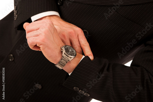 Successful businessman in formal suit chacking time on wrist wat photo